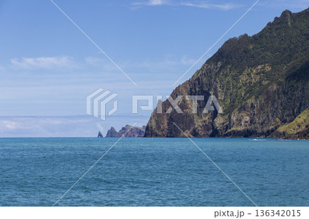Atlantic cliffs and sea stacks near Porto da Cruz Madeira Portugal, calm blue water 136342015