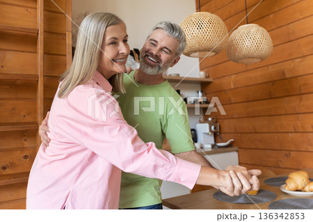 Older adults moving playfully in kitchen setting Older adults moving playfully in kitchen setting 136342853