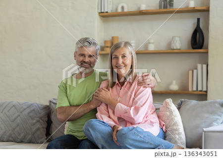 Mature people embracing and sitting on sofa enjoying moment of love 136343051