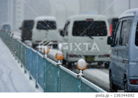 走る車に降り積もった雪とオレンジの視線誘導標 新荒川大橋 走る車に降り積もった雪とオレンジの視線誘導標 新荒川大橋 136344892