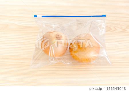 ジッパー付きのビニール保存袋に入ったタマネギ 136345048