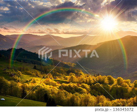 gorgeous countryside in spring at sunset. beautiful mountain landscape with cloudy sky over the forested rolling hills in evening light. scenery with atmospheric weather and rainbow in highland vista gorgeous countryside in spring at sunset. beautiful mountain landscape with cloudy sky over the forested rolling hills in evening light. scenery with atmospheric weather and rainbow in highland vista 136345072