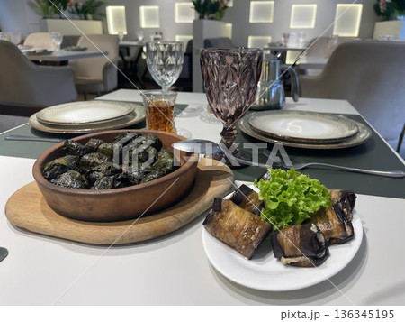 a bowl of dolma and badrijani's plate on a table 136345195