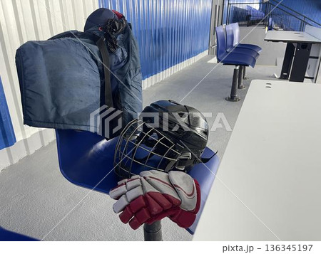 hockey glove and helmet with pants on the chair in ice stadium hockey glove and helmet with pants on the chair in ice stadium 136345197