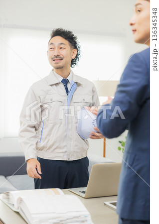 会社で資料を見ながら打ち合わせするエンジニア 136345348