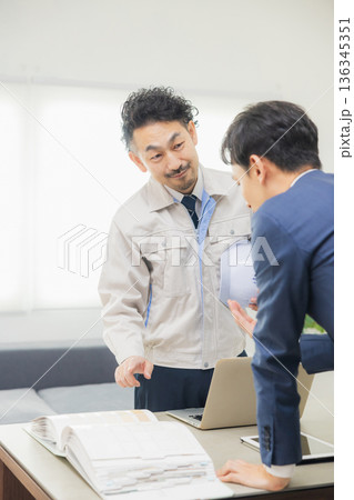 会社で資料を見ながら打ち合わせするエンジニア 136345351