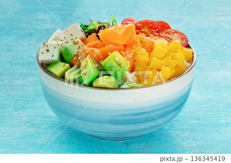 Salmon poke bowl with mango, avocado, tofu, wakame, cherry tomatoes Salmon poke bowl with mango, avocado, tofu, wakame, cherry tomatoes 136345419