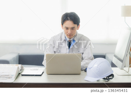 オフィスでスマホを見るエンジニア 136345431