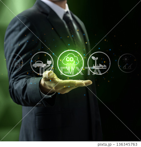 Businessman displaying icons for carbon reduction, green energy, and ESG, symbolizing corporate commitment to sustainability and climate change mitigation for a net zero future 136345763