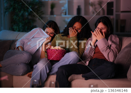 Terrified diverse friends watching horror movie on tv 136346146