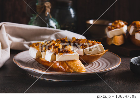 Snack sandwiches with brie cheese and caramelized onions on a plate on the table Snack sandwiches with brie cheese and caramelized onions on a plate on the table 136347508