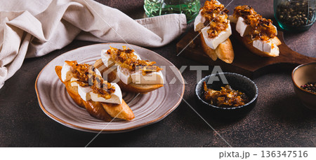 Snack sandwiches with brie cheese and caramelized onions on a plate on the table web banner Snack sandwiches with brie cheese and caramelized onions on a plate on the table web banner 136347516