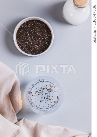 Refreshing coconut water drink with chia seeds in a glass on the table top and vertical view Refreshing coconut water drink with chia seeds in a glass on the table top and vertical view 136347536