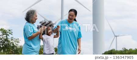 Family with daughter walking on field on wind farm. Family with daughter walking on field on wind farm. 136347905