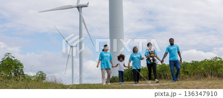 Family with daughter walking on field on wind farm. Family with daughter walking on field on wind farm. 136347910