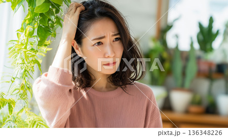 抜け毛と髪のダメージに悩む若い女性の深刻なポートレート 抜け毛と髪のダメージに悩む若い女性の深刻なポートレート 136348226