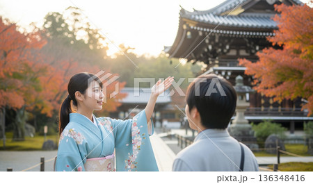 手のひらを上げ日本の寺院を案内する女性 136348416