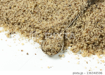 Crushed walnut kernels in spoon close-up on white background. Crushed walnut kernels in spoon close-up on white background. 136348596