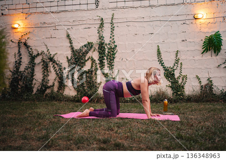 Mother embraces wellness with exercise after childbirth in serene garden Mother embraces wellness with exercise after childbirth in serene garden 136348963