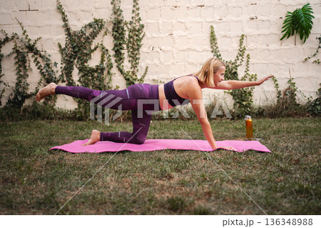 Mother embraces fitness with strength exercises in a serene garden setting Mother embraces fitness with strength exercises in a serene garden setting 136348988