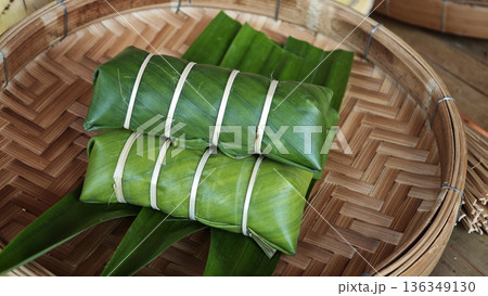 Sticky Rice with Banana Filling Wrapped in Banana Leaves,before cooking. 136349130
