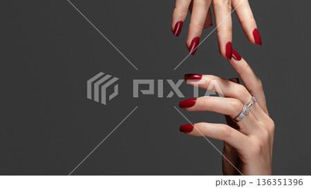 Beautiful glamour photo of elegant female hands with bright burgundy manicure on gray background. Long square nails with dark red gel polish. Luxury fashion style of brilliants jewelry rings Beautiful glamour photo of elegant female hands with bright burgundy manicure on gray background. Long square nails with dark red gel polish. Luxury fashion style of brilliants jewelry rings 136351396