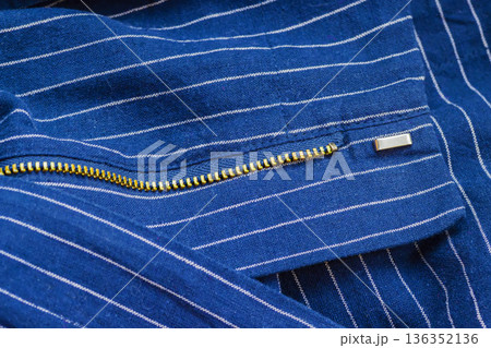 Blue Fabric With Zipper. Close up of fabric with golden metal zipper, garment construction detail, apparel production. Natural background of fabric texture of fashion design sewing process manufacture 136352136
