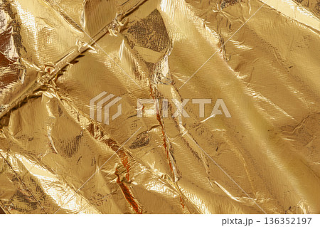 Crumpled gold foil texture with shiny metallic surface, rich reflective details filling entire frame. Luxury gold backdrop, premium gold background, abstract design for mockup 136352197