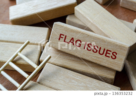 FLAG ISSUES text on wooden blocks highlighting early risk identification and compliance awareness. 136353232