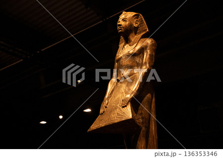 Ancient Egyptian Pharaoh Statue in Museum with Dramatic Lighting Ancient Egyptian Pharaoh Statue in Museum with Dramatic Lighting 136353346
