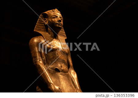 Ancient Egyptian Pharaoh Statue in Museum with Dramatic Lighting 136353396