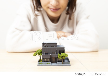住宅模型を見つめる女性 住宅模型を見つめる女性 136354202