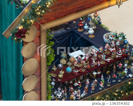 Festive Christmas market stall showcases myriad Santa Claus and themed holiday ornaments, promoting seasonal cheer and traditional festive gift shopping 136354302