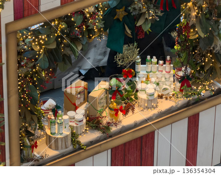 Festive Christmas market stall presents natural cosmetic and organic skincare products adorned with glowing lights and winter foliage, inspiring holiday gift ideas 136354304