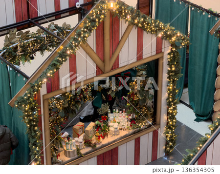 Festive Christmas market stall adorned with sparkling lights and green garlands, showcasing unique artisan gifts for seasonal celebrations Festive Christmas market stall adorned with sparkling lights and green garlands, showcasing unique artisan gifts for seasonal celebrations 136354305
