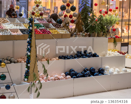 Colorful Christmas ornaments and festive decorations displayed for sale in a vibrant retail store, evoking holiday spirit and seasonal shopping joy Colorful Christmas ornaments and festive decorations displayed for sale in a vibrant retail store, evoking holiday spirit and seasonal shopping joy 136354316