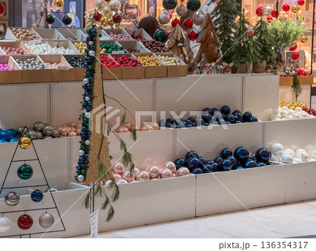 Vibrant Christmas ornaments and diverse holiday decorations are attractively displayed in a retail store, inviting shoppers to prepare for festive seasonal celebrations Vibrant Christmas ornaments and diverse holiday decorations are attractively displayed in a retail store, inviting shoppers to prepare for festive seasonal celebrations 136354317