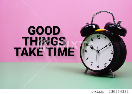 Black alarm clock on a pastel green and pink background with the text "Good Things Take Time" Black alarm clock on a pastel green and pink background with the text "Good Things Take Time" 136354382