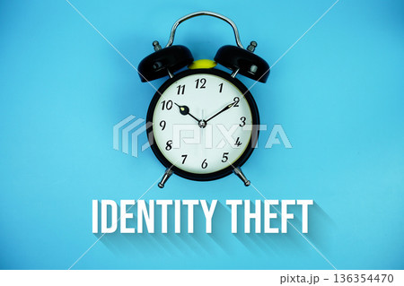 Identity Theft text and alarm clock on blue background Identity Theft text and alarm clock on blue background 136354470