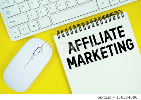 Notepad with the text "Affiliate Marketing" with white keyboard and wireless mouse on yellow background Notepad with the text "Affiliate Marketing" with white keyboard and wireless mouse on yellow background 136354680