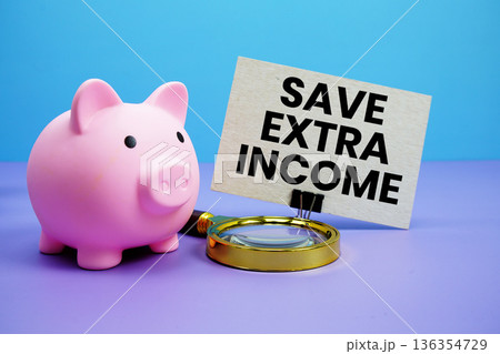 Save Extra Income text with piggy bank and magnifying glass on blue and purple background Save Extra Income text with piggy bank and magnifying glass on blue and purple background 136354729
