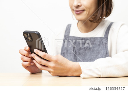 スマホを使うミドル女性 136354827