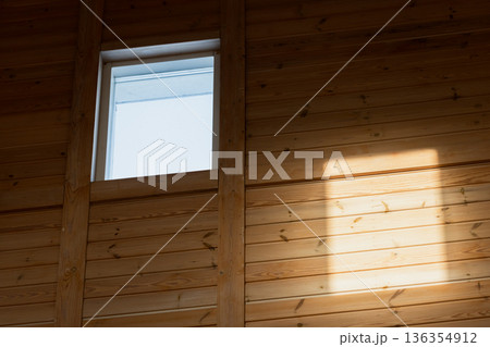 A cozy wooden interior wall bathed in warm sunlight A cozy wooden interior wall bathed in warm sunlight 136354912