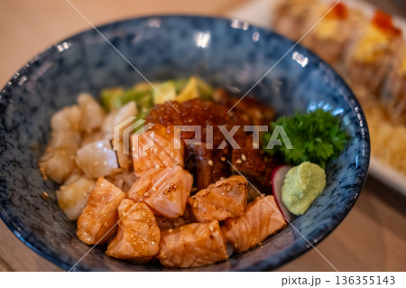 Donburi, a Japanese rice bowl dish of seafood. Including raw fish such as Salmon, Ikura, Unagi, and Avocado 136355143