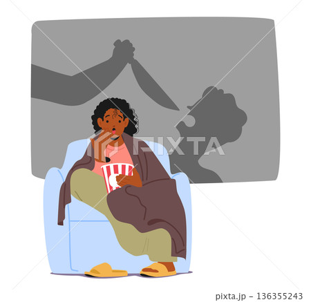 Frightened woman sitting on armchair, eating popcorn while watching scary thriller movie scene 136355243