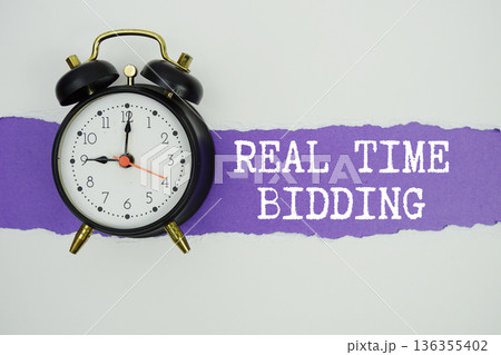 Real Time Bidding text on purple with white paper torn ripped of horizontal and alarm clock Real Time Bidding text on purple with white paper torn ripped of horizontal and alarm clock 136355402