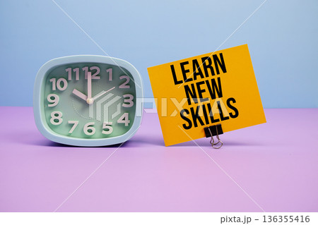 Learn New Skills text and alarm clock on blue and purple background 136355416