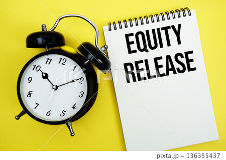 Equity Release text with alarm clock flat lay on yellow background 136355437