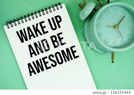 Wake Up And Be Awesome text with alarm clock flat lay on green background Wake Up And Be Awesome text with alarm clock flat lay on green background 136355444