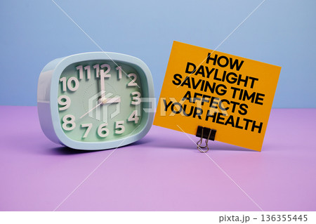 How Daylight Saving Time Affects Your Health text and alarm clock on blue and purple background 136355445